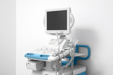 Ultrasound machine near white wall. Medical equipment
