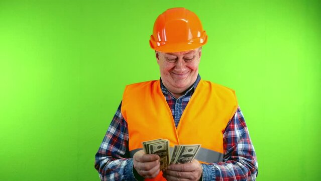 Builder in hardhat counts money from and dancing.