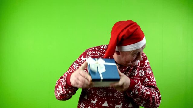 Man in Santa hat and Xmas sweater opening gift box