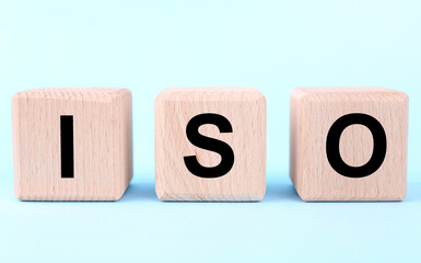International Organization for Standardization. Wooden cubes with abbreviation ISO on light blue...