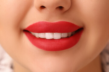 Fototapeta premium Beautiful smiling woman with red lipstick, closeup