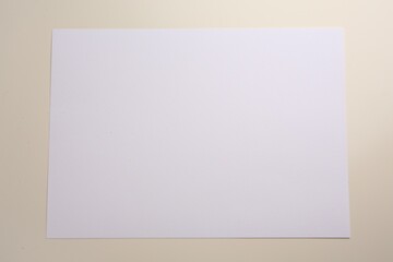 Sheet of parchment paper on beige background, top view