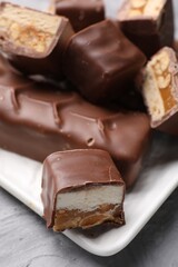 Tasty chocolate bars with nougat on table, closeup
