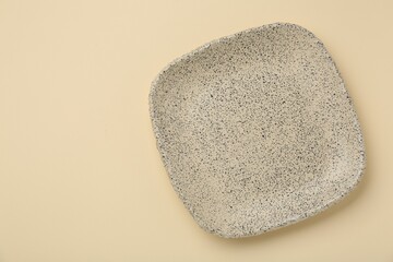 Beautiful ceramic plate on beige background, top view. Space for text