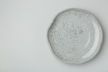 Beautiful ceramic plate on light gray background, top view. Space for text