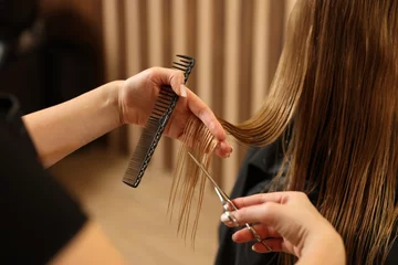 Fototapete Schönheitssalon Professional hairdresser cutting girl's hair in beauty salon, closeup