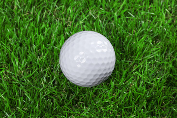 One golf ball on green grass, closeup