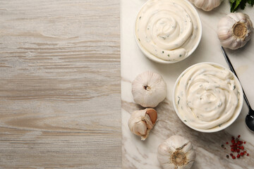 Tasty sauce with garlic and spoon on light wooden table, top view. Space for text