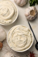 Tasty sauce with garlic and spoon on table, flat lay