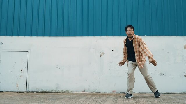 Hispanic funny choreographer dancing in hip hop style. Young happy break dancer perform b-boy dance. Motion shot of funny man practicing street dancing. Outdoor sport 2024. Modern dance. hiphop.