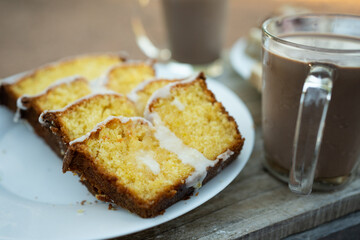 Close-up of a lemon and orange pudding, next to it a glass of chocolate milk.