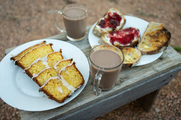 A complete snack: Orange and lemon pudding, chocolate drink, toast with butter, and toast with cheese and strawberry jam