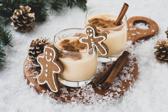 Glasses of egg nog with cinnamon and gingerbread cookies.
