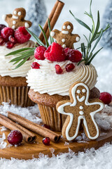 Decadent gingerbread cupcakes with buttercream frosting, garnished with berries.