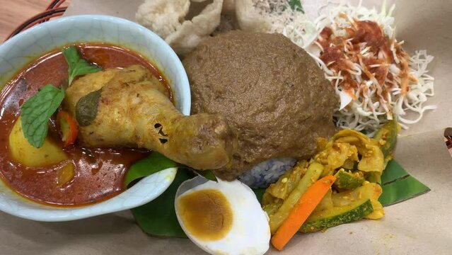 Nasi Kerabu or nasi ulam, popular malay rice dish with curry chicken. Traditional Malaysia cuisine. Panning view.