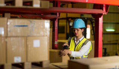 Hispanic woman wearing work clothes working in a distribution warehouse - obrazy, fototapety, plakaty
