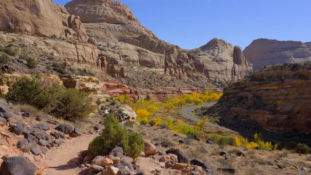 Establishing shot of mountain trail with red rocks in Hickman Natural Bridge Trail, Capital Reef National Park, Utah, North America. ProRes 422 HQ.