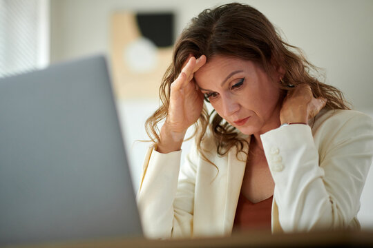 Sad stressed overworked female entrepreneur suffering from migraine headache