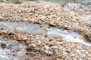 Mountain river spring season with sand and stone shoals along the banks.