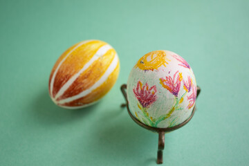 dos huevos de pascua decorados a mano con flores y colores