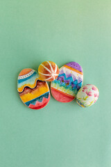 dos huevos decorados de pascua con dos galletas en forma de huevo decorados a mano