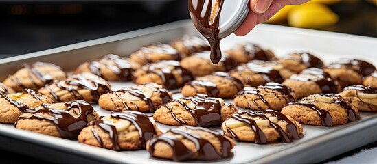Preparing banana cookies with chocolate drizzle by using a scoop to place batter on a lined baking sheet for baking.