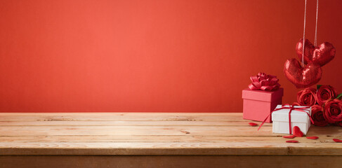 Valentine's day background with empty wooden table, gift box and heart shapes. Holiday mock up for...