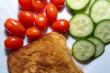 Breakfast with fried egg toast, tomatoes and cucumbers
