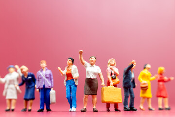 Obraz premium Miniature people , A group of women stand together On a pink backdrop, International Women's Day concept