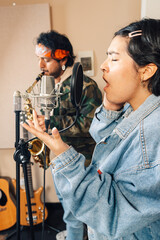 Singer and saxophonist in studio recording a new song