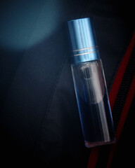 A small bottle of perfume. Natural men's perfume on a black background