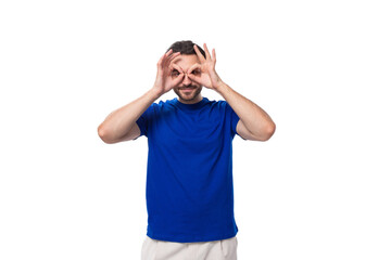 Fototapeta premium young attractive brunette man with a beard in a blue t-shirt with a mockup on a white background with copy space