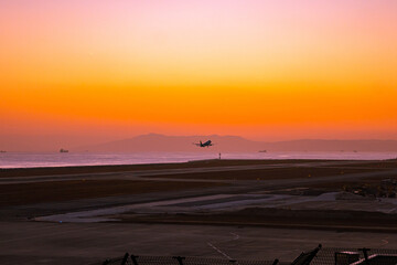 Obraz premium 夕暮れ時の空を飛ぶ飛行機