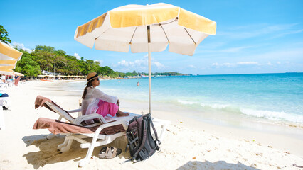 Asian woman on a beach chair on the beach of Koh Samet Island Rayong Thailand, the white tropical beach of Samed Island with a turqouse colored ocean