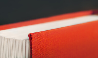 Side view of a thick red hardback book, macro