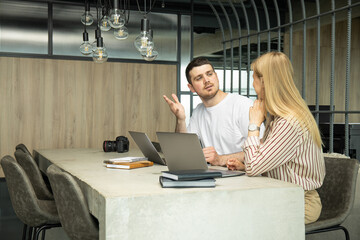 A young guy and a girl work on a laptop
