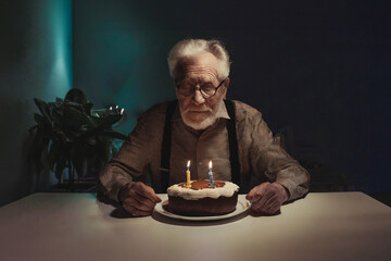 sad or depressed or angry grandpa, old man on birthday, on a chair at a table with a birthday cake