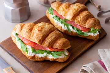 Croissants with salmon, white cheese and arugula. Breakfast.