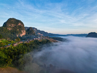 Aerial drone view of a hill tribe village in northern Thailand with set amidst sea of mist on a clear day