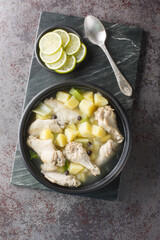 Bahamian Chicken Souse with chicken wings, potatoes, celery, lime and spices closeup on the plate on the table. Vertical top view from above