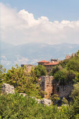 Fototapeta na wymiar Scenic view of Alania. Houses and villas on the slopes of peninsula, the old part of city. Vertical shot. Alanya (Antalya region), Turkey (Turkiye)