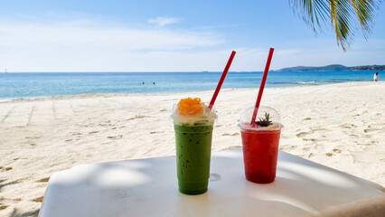 Cold green tea and strawberry shake tropical drinks on the beach of Koh Samet Island Rayong Thailand, Iced Thai Green Milk Tea