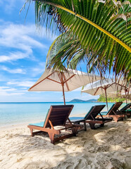 Fototapeta na wymiar beach chairs sunbed with umbrellas at the white tropical beach of Samed Island with a turqouse colored ocean of Koh Samt Island Thailand