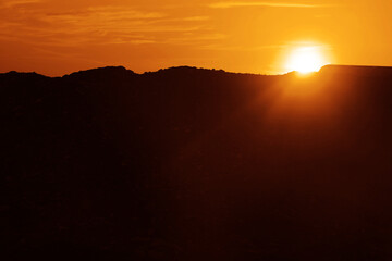 sunshine. colorful sunset on top of Caucasian mountains. Sunset in mountain over peak. Sun light and early morning or evening mountain yellow, orange sky background. sunrays. sun beam.