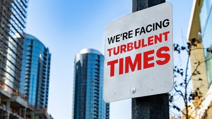 We're facing turbulent times on a sign in a city business district