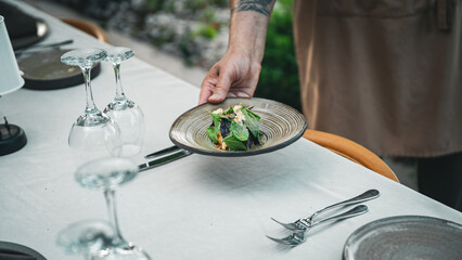 chef serving salad on table