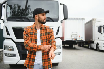 Portrait of young bearded trucker standing by his truck vehicle. Transportation service. Truck...