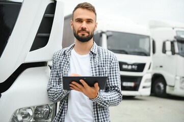 Portrait of young bearded trucker standing by his truck vehicle. Transportation service. Truck...