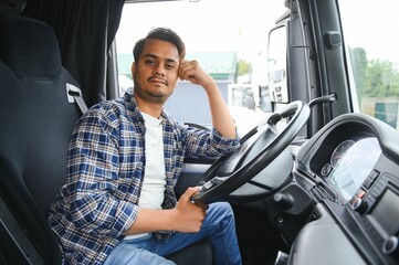 Portrait of a young handsome Indian truck driver. The concept of logistics and freight...