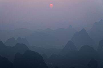 Scenic view of the foggy sunrise over mountains in Yangshuo, China
